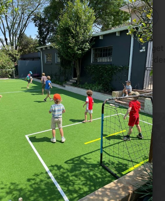 Children playing on a NineCourts Astro Turf play area at a residential property