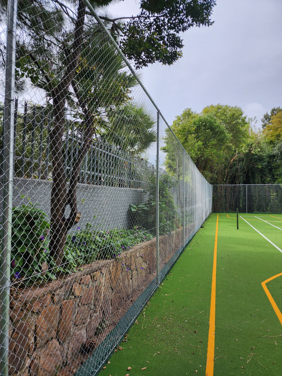 LG Diamond Mesh fencing installation by NineCourts — galvanised chain-link enclosure around an Astro Turf court