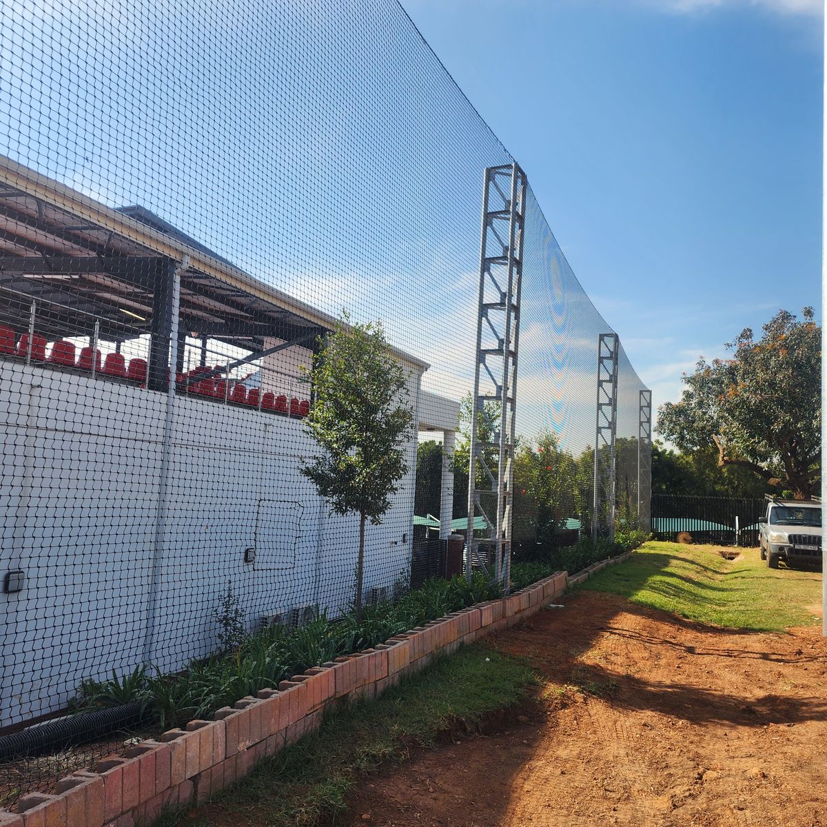 High-mast nylon ball catcher netting installation by NineCourts at a stadium